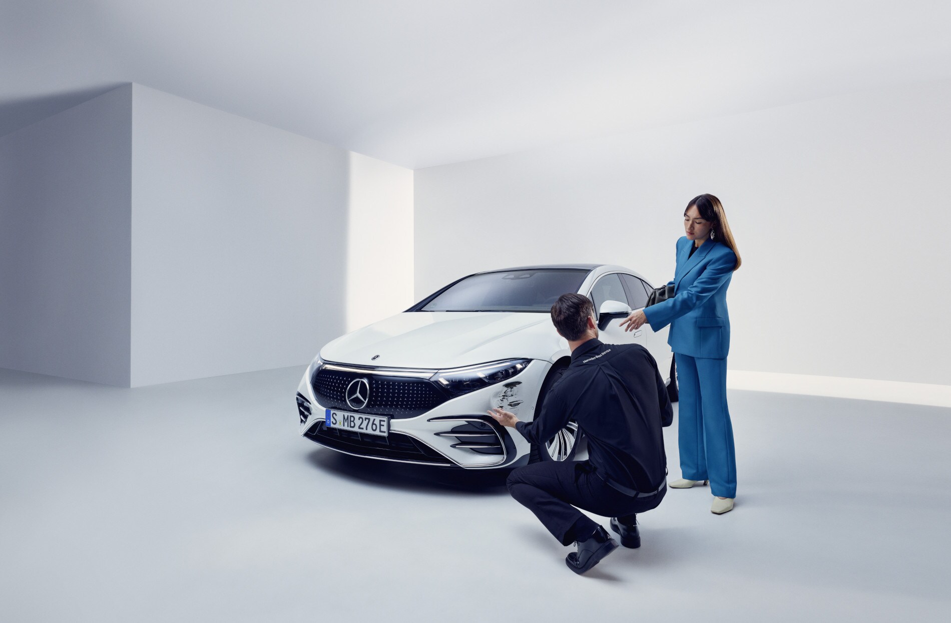 Hasar ve Arıza | Mercedes-Benz Hasarlı bir Mercedes-Benz'in yanında diz çöken Mercedes-Benz destek ekibinden bir adam